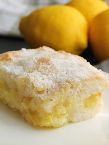 Lemon coffee cake sprinkled with sugar - whole lemons in the background.