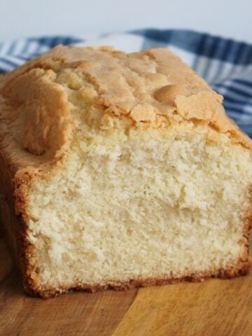 Square photo of Mother's Loaf Cake - fluffy and delicious on a brown board.