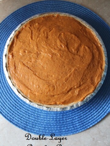 overhead view of pumpkin pie on a blue mat.