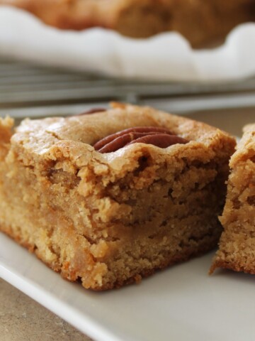 Closeup of a blondie with a pecan on top.