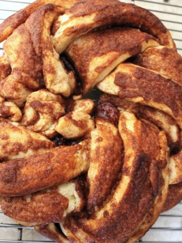Cinnamon twisty bread on a cooling rack.
