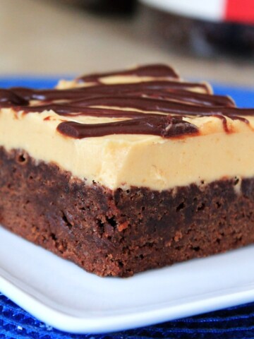 Chewy chocolate brownie topped with fluffy peanut butter frosting and drizzled with chocolate.