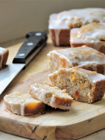 Peach cobbler bread mini loaves on a cutting board, sliced.
