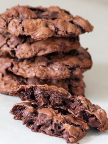 Stack of gooey chocolate cookies, with one split in half.