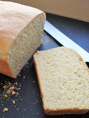 Loaf of homemade bread, sliced on a bread tray.