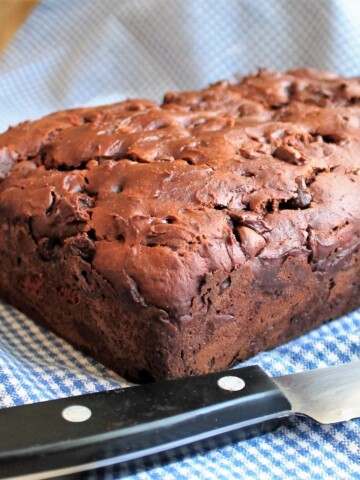 Loaf of chocolate bread on a blue checked cloth.