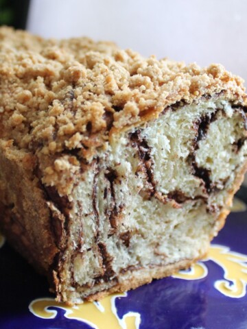 Babka with chocolate swirls on a blue and gold plate.