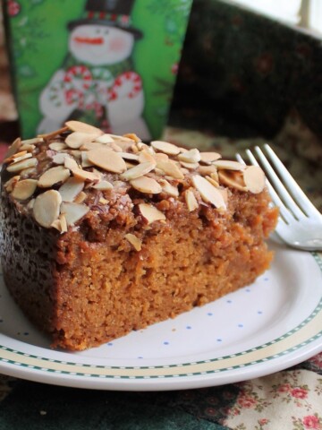 Slice of sticky toffee cake on a festive plate with a fork.