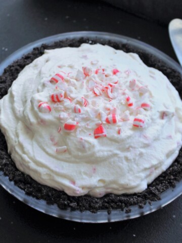 Whole peppermint pie with Oreo crust, sprinkled with crushed peppermint candy.