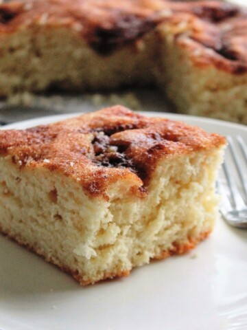 Slice of rich vanilla sugar cake on a white plate.