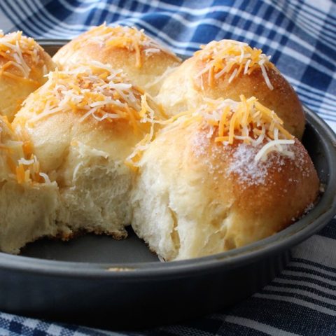 Pull-apart bread in a pan on a blue and white cloth.