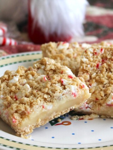 Close up of peppermint crumble bar on a festive plate with peppermints strewn around the plate