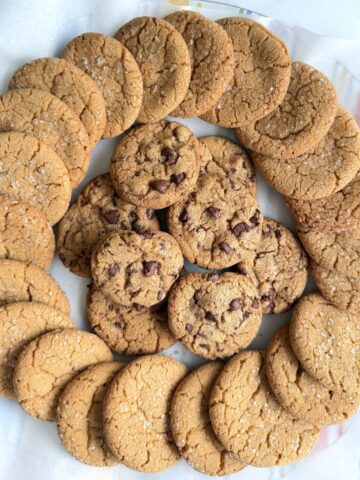 Overhead view of a circle of Biscoff sugar cookies as well as a pile with chocolate chips in them.